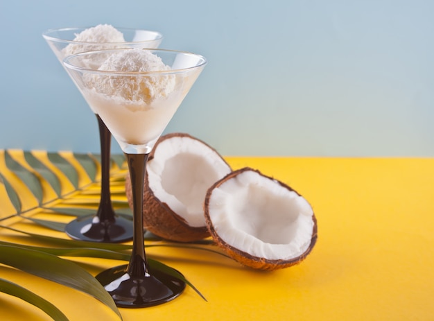 Coconut ice cream on the yellow table with palm leaf and coconut