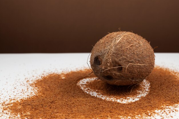 Coconut is lying on table with sprinkled coconut palm sugar