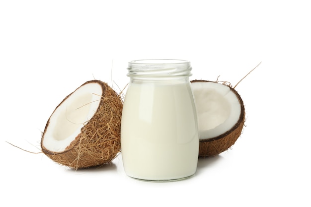 Coconut and jar of coconut milk isolated on white