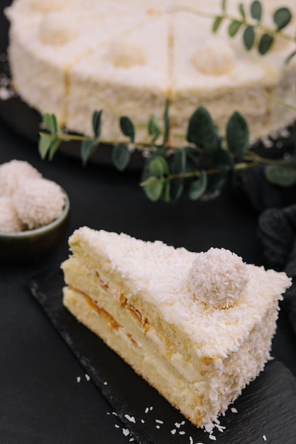 Coconut layered raffaello cake on black tray