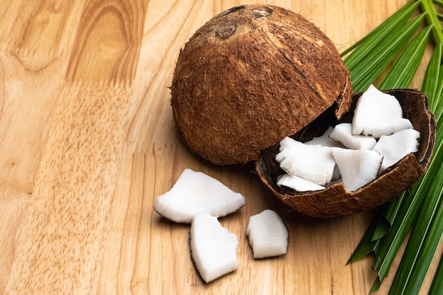 Coconut meat and coconut leaf on wooden table