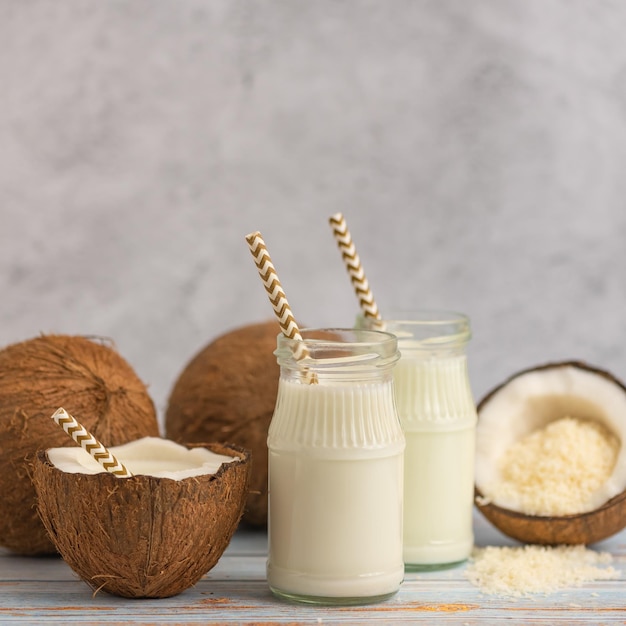 Photo coconut milk and coconuts on a dark wood background the toning selective focus