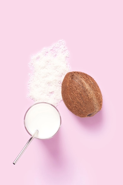 Coconut milk in a glass cup on a pink