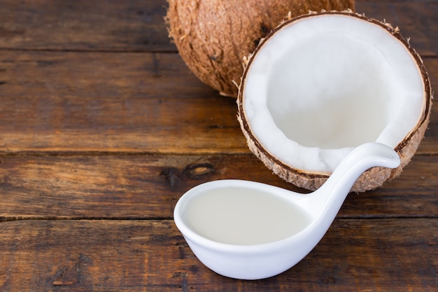 Coconut milk and half coconut on wooden desk