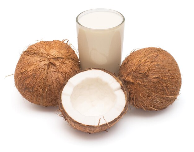 Coconut milk with fresh whole nut and half isolated on a white background Creative cosmetic concept Top view flat lay