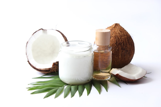 Coconut oil and coconuts, palm branches close up. High quality photo