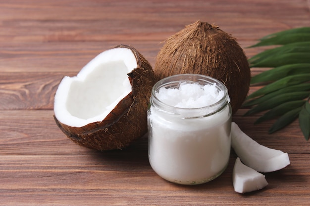 Coconut oil and coconuts palm branches close up