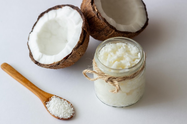 Coconut oil in a jar and fresh coconuts. Natural cosmetics.