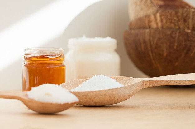 Coconut oil in jar and wooden spoon. Nature body, face, hair care concept.