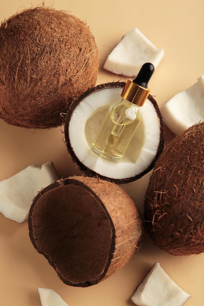 Coconut oil with coconut on beige background. Top view
