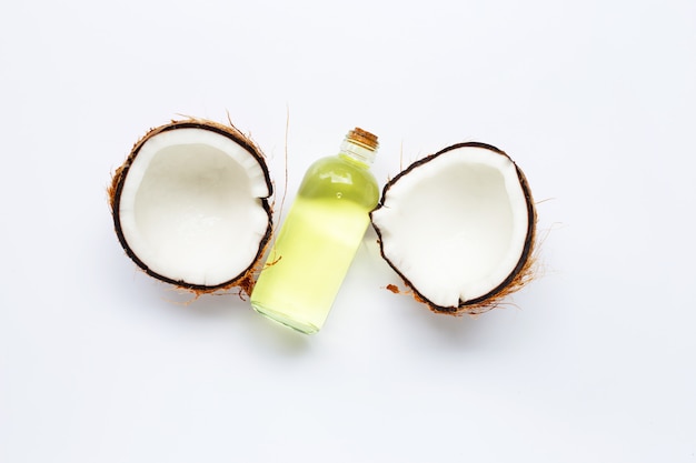 Coconut oil with coconuts on white