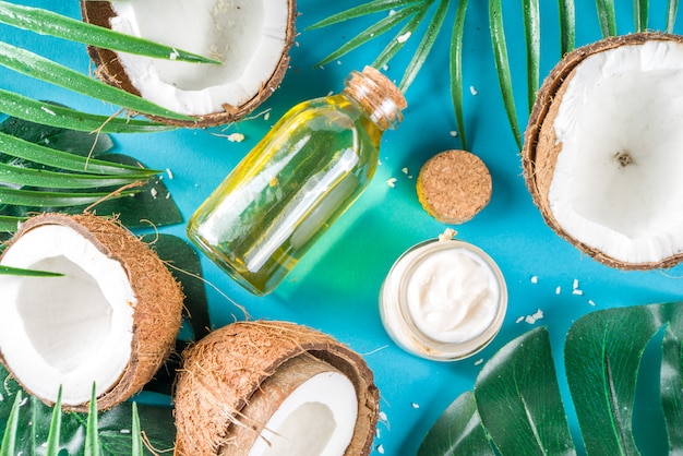 Coconut oil with fresh coconuts. Tropical summer background