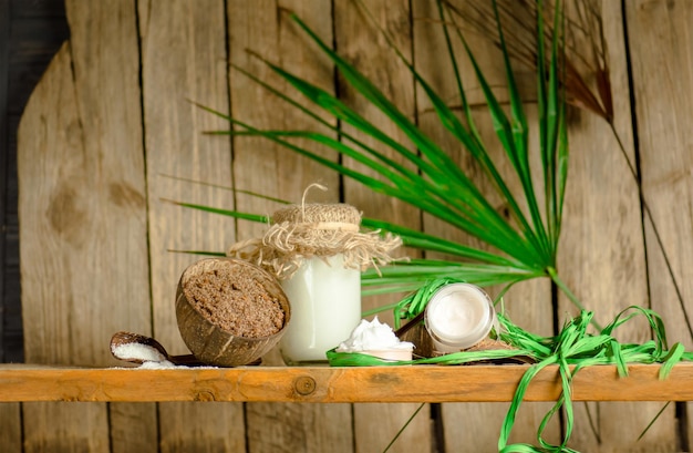 Coconut oil with fresh nut on old wooden table Coconut oil and coconuts Organic coconut products for spa