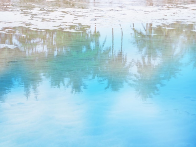 Foto palme da cocco e cielo blu riflesso su sfondo spiaggia sabbiosa