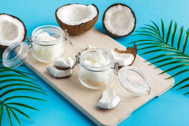 Photo coconut pieces on wooden board on blue