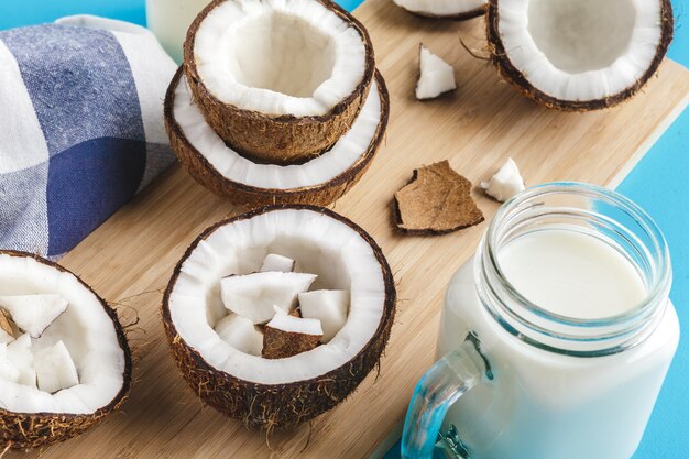 Coconut pieces on wooden board on blue 