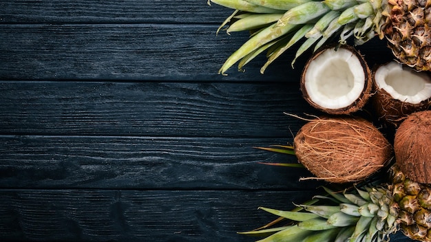 Coconut and pineapple on a wooden background Tropical fruits and nuts Top view Free space for text