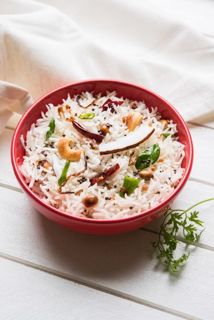 Coconut Rice - South Indian recipe using leftover cooked Basmati rice, served in a red bowl over moody background, selective focus