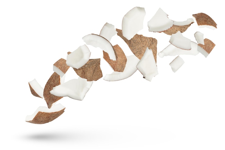 Photo coconut slices on a white isolated background coconut slices scatter in different directions from different sides and cast a shadow of different sizes