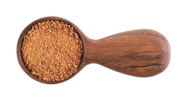 Coconut sugar isolated on white background brown unrefined coconut palm sugar in wooden spoon top