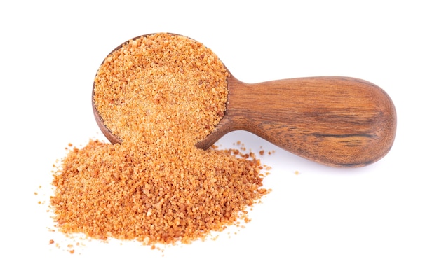 Coconut sugar isolated on white background brown unrefined coconut palm sugar in wooden spoon