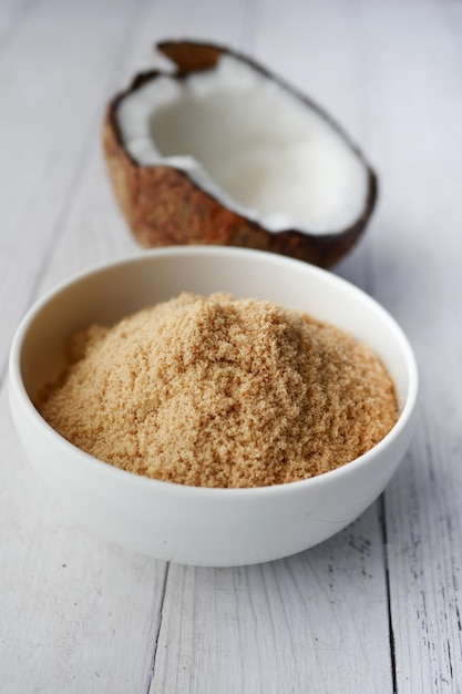 Coconut sugar in a white bowl on table