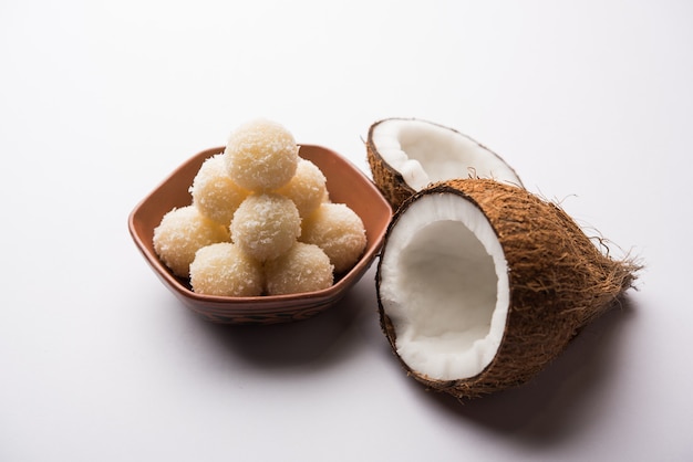 Coconut Sweet Laddoo 또는 Nariyal Ladduis는 인도에서 인기 있는 축제 음식입니다. 변덕스러운 배경 위에 제공, 선택적 초점