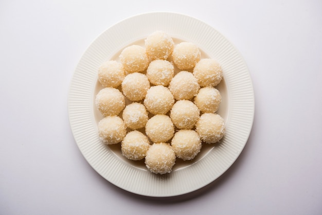 Coconut Sweet Laddoo 또는 Nariyal Ladduis는 인도에서 인기 있는 축제 음식입니다. 변덕스러운 배경 위에 제공, 선택적 초점