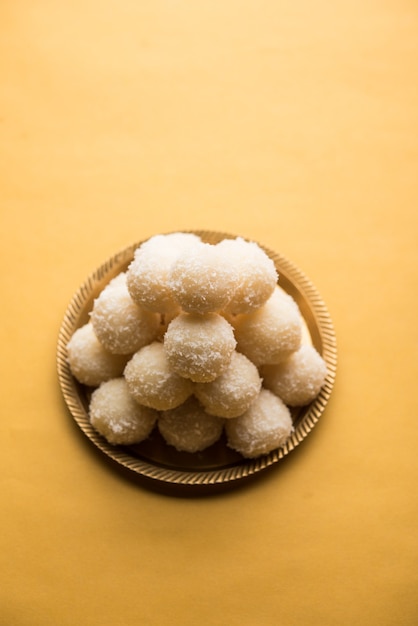 Coconut Sweet Laddoo 또는 Nariyal Ladduis는 인도에서 인기 있는 축제 음식입니다. 변덕스러운 배경 위에 제공, 선택적 초점