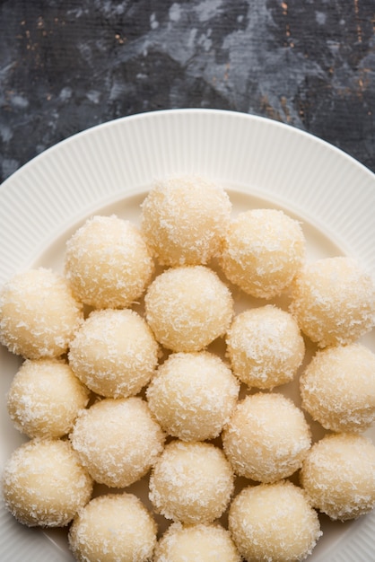 Foto coconut sweet laddoo of nariyal ladduis een populair festivalvoedsel uit india. geserveerd op een humeurige achtergrond, selectieve focus