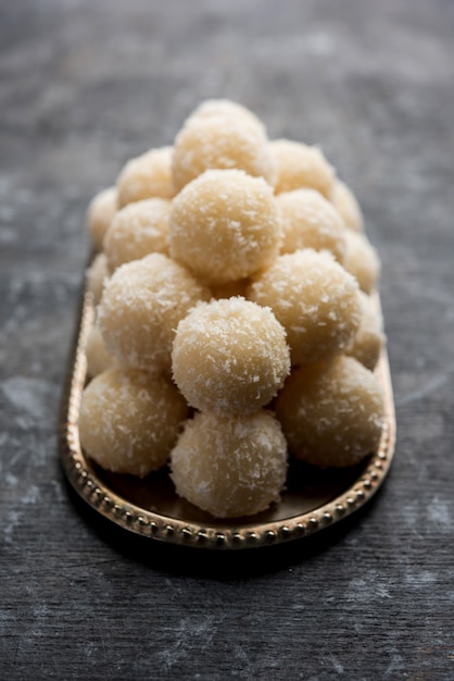 Coconut Sweet Laddoo OF Nariyal Ladduis een populair festivalvoedsel uit India. Geserveerd op een humeurige achtergrond, selectieve focus