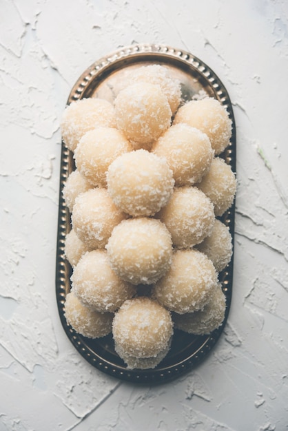 Coconut Sweet Laddoo OF Nariyal Ladduis een populair festivalvoedsel uit India. Geserveerd op een humeurige achtergrond, selectieve focus