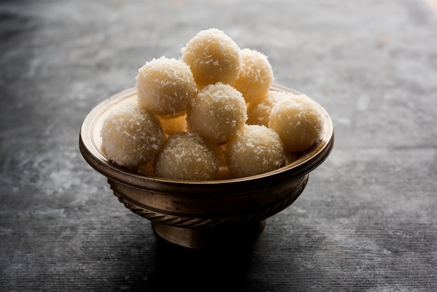 사진 coconut sweet laddoo 또는 nariyal ladduis는 인도에서 인기 있는 축제 음식입니다. 변덕스러운 배경 위에 제공, 선택적 초점