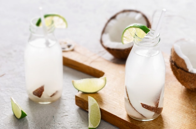 Coconut water in bottles on wooden table. Healthy drinks concept