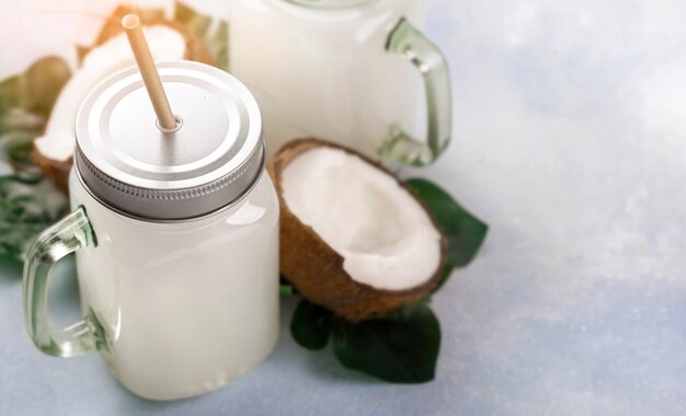 Coconut water tropical drink in glass jar with handle copy space