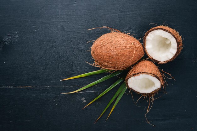 Coconut on a wooden background. Tropical fruits and nuts. Top view. Free space for text.