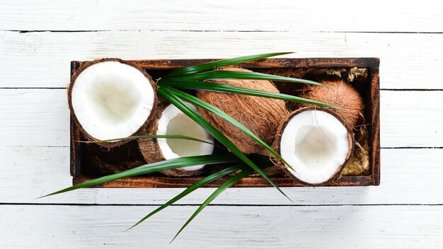 Noce di cocco in una scatola di legno. frutti tropicali. noce. vista dall'alto. spazio libero per il tuo testo.