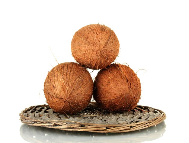 Coconuts on wicker mat isolated on white