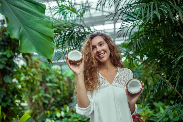 Coconuts. Woman in white dress with coconut in her hands