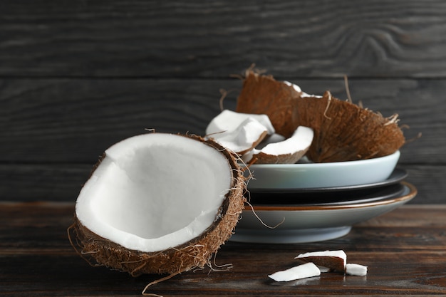 Coconuts on wooden table against dark