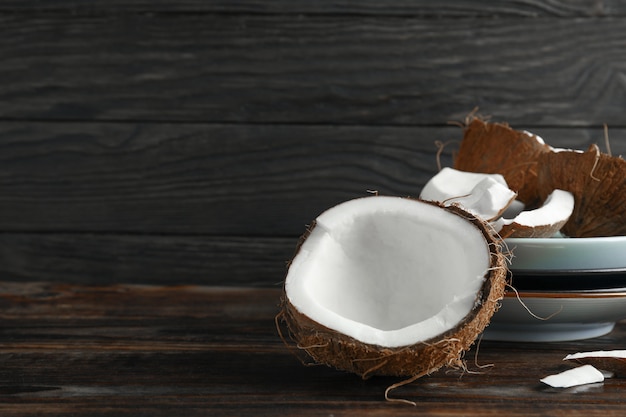 Coconuts on wooden table against dark