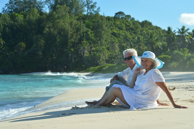 Cocouple sitting on tropical beach