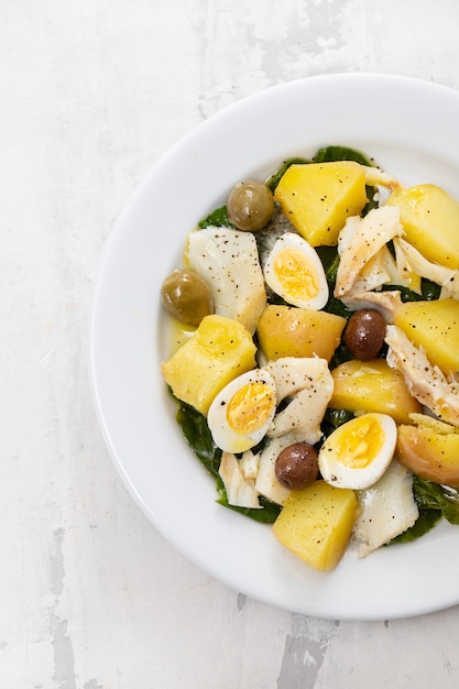 Cod fish with vegetables and boiled egg on dish