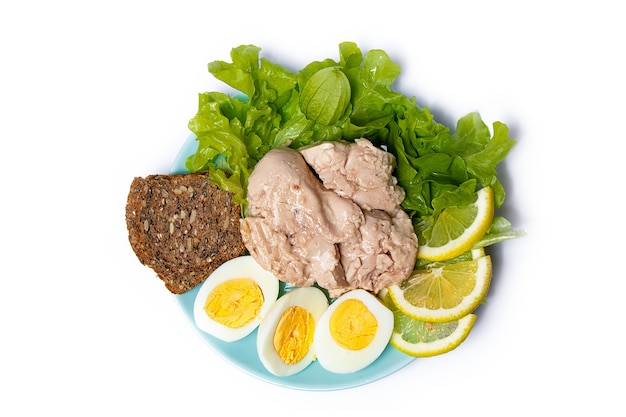 cod liver in oil with lettuce leaves and lemon on white, top view