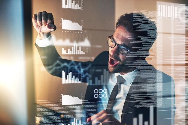 Photo codecracked cropped shot of a handsome young businessman cheering while coding late in the office