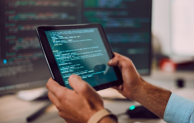 Codeertablet in handen met man webdesign en software-update computer met informatietechnologie en code Cybersecurity ux en netwerk met wifi-programmeur en cyberspace met programmeren