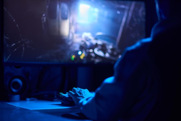 a coder is working late at night on a computer screen coding and using a smartphone app