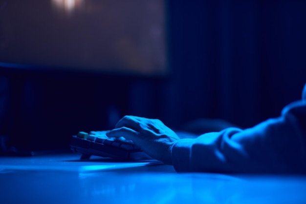 コーダーがコンピュータースクリーンで深夜にコーディングをしてスマートフォンアプリを使用しています