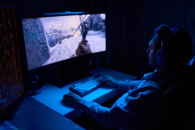 一名編碼員深夜在電腦屏幕上工作,編碼並使用智能手機應用程式