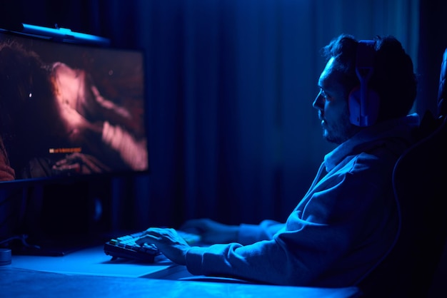 a coder is working late at night on a computer screen coding and using a smartphone app